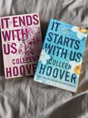 It Ends With Us & It Starts With Us - Två populära romaner av Colleen Hoover: 'It Ends With Us' med rosa omslag och blommotiv samt 'It Starts With Us' med blått omslag och vita blommor. Perfekta för dig som gillar gripande och känslosamma berättelser om kärlek och relationer.