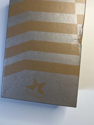 Superstar sneakers från Golden Goose - Snygga vita sneakers från Golden Goose med grå stjärndetalj på sidan och grå skosnören. Skorna har en klassisk låg siluett och är tillverkade i läder med mockadetaljer vid häl och stjärna. Perfekta för en clean och trendig look.