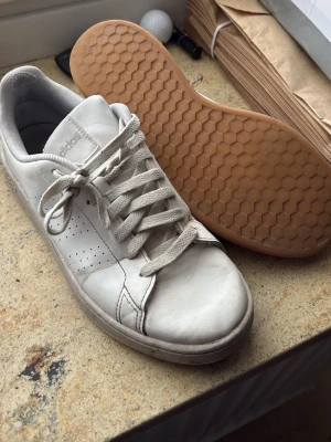 Vita Adidas sneakers med gummisula - Säljer ett par vita adidas sneakers i storlek 40 då jag inte kan ha dom längre. Använt under 1 sommar 