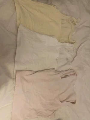 Tre ärmlösa linnetoppar i pastell - Säljer tillsammans. Vita har ett litet hål långt ner på ryggen.’