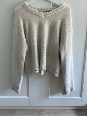 Beige stickad tröja från Kappahl - Mysig beige stickad tröja från Kappahl med v-ringad hals och avslappnad passform. Tröjan har långa ärmar och ribbade muddar vid ärmslut och nederkant. Perfekt för lager på lager och enkel att matcha till olika outfits. Köpte för 400 så jag försöker göra det billigt så mycket jag kan 💗🫶