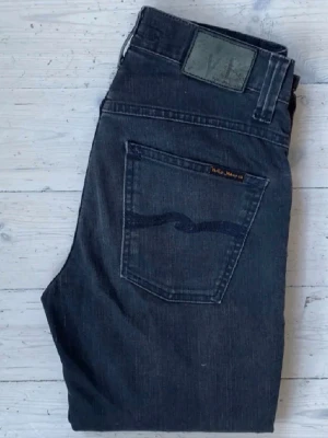 Nudie grim Tim - Säljer ett par mörkgråa nudie. Modellen heter grim Tim som ni ser på 4e bilden. Skicket är bra utan defekter. Modellen på bild 5 är 180 och väger 65. Skriv för mer frågor.