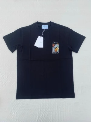Svart t-shirt från Casablanca - Snygg svart t-shirt från Casablanca med färgglad broderad logga och texten 'CASA BLANCA' på bröstet. Klassisk passform och rund hals. Tillverkad i mjuk bomull som känns skön mot huden. Perfekt för dig som gillar stilrena plagg med en twist.