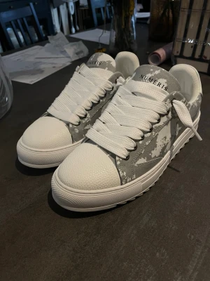 Gråa Numeris sneakers  - Säljer helt nya numeris sneakers som jag fick i present, alldrig haft på dom ute. Säljer p.g.a att dom är för små på min fot, skorna är storlek 46 men jag skulle säga att dom passar 45-45,5