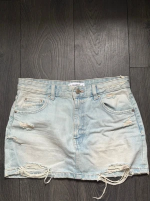 Jeanskjol - Ljus jeanskjol med slitningar från Pull & Bear. Storlek M. 