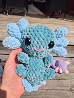 Söt handvirkad Axolotl i sammetsgarn ✨ - Ca 20 cm lång axolotl virkad i supermjuka Baby Snuggles (100% polyester). Nygjord i rökfritt hem. .🧼 Tvättråd: Handtvätt eller skontvätt i tvättpåse (max 30°), lufttorkas.🧸 Säkerhet: Innehåller säkerhetsögon av plast. Rekommenderas ej till barn under 3 år utan tillsyn. Fraktas spårbart via Plick. Spana gärna in min profil för fler figurer! 
