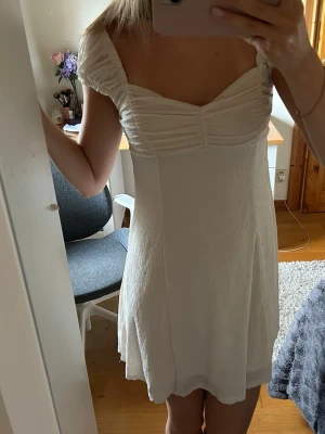 Vit kort sommarklänning - Söt vit kort klänning med puffiga axelband som man kan ha som offshouldee💖 Perfekt för varma dagar och somriga tillfällen som midsommar eller skolavslutning. Storlek M men passar som s, använd en gång 