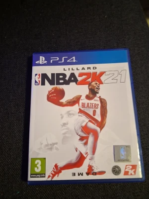 NBA 2K21 till PS4 - Basketspel till PlayStation 4, NBA 2K21, med omslag i vitt och blått. Spelet har en ikonisk basketspelare på framsidan och är utvecklat av 2K. Perfekt för dig som gillar sportspel och vill spela med vänner eller själv.