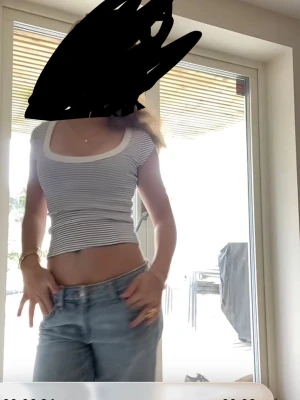 Randig croppad topp med rund ringning - Säljer en vit och mörkblå randig croppad topp med korta ärmar och bred rund ringning. Toppen har en slim passform och är tillverkad i mjukt bomullsmaterial. Perfekt för en avslappnad och trendig stil. Såååååå fiiin tröja att ha i sommar🤗🤗🤗❤️