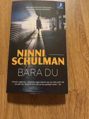 Bara du av Ninni Schulman - Säljer spänningsromanen 'Bara du' av Ninni Schulman. Boken har ett omslag i mörka färger med gul och vit text, och är i pocketformat. Handlingen utspelar sig i Stockholm och kretsar kring kärlek, ensamhet och oväntade vändningar.
