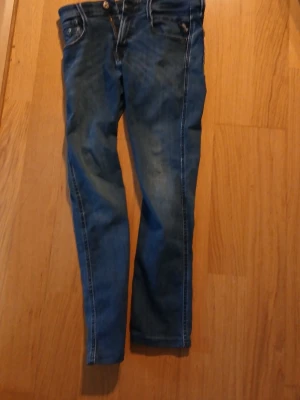 Blå replyjens  - Snygga blå replyjens med vita kontrastsömmar och klassisk femficksdesign. Jeansen har låg midja och smal passform hela vägen ner. Tillverkade i denim med lätt tvättad look och detaljerade bakfickor.