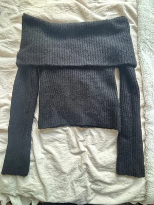 Stickad off shoulder tröja - Mjuk stickad tröja som är off shoulder. Tröjan är ribbad och har långa armar. 