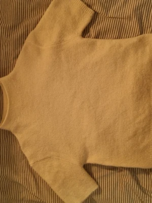 Vit stickad tröja från Gina Tricot - Stickad vit tröja från Gina Tricot. Modellen har korta ärmar och rund halsringning. Enkel och stilren design som passar till mycket. Materialet känns fluffigt och bekvämt mot huden.