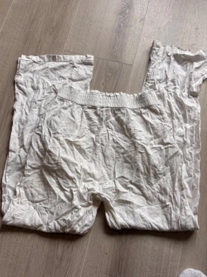 Vita linnebyxor med resårmidja - Säljer ett par vita linnebyxor med avslappnad passform och bred resår i midjan. Byxorna är raka i modellen och perfekta för varma dagar. Materialet är svalt linne och färgen är klassiskt vit. Enkla att matcha till olika stilar!