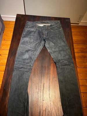 Vintage Mörkblå jeans från IIJIN - Snygga mörkblå jeans från Levi's med klassisk femficksdesign och raka ben. Jeansen har kontrastsömmar och detaljerade bakfickor med bruna sömmar samt röd Levi's-tag. Perfekta för en stilren och avslappnad look. 34/34 nypris 3000kr
