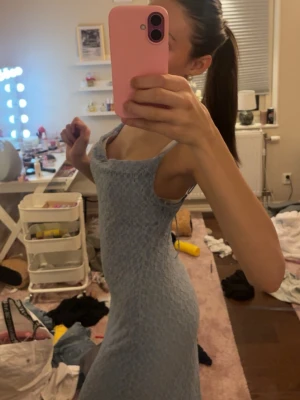 Ljusblå spetsklänning med smala band - Säljer en ljusblå klänning med smala axelband och v-ringad hals. Klänningen är figurnära och täckt av ett fint spetsmönster som ger en romantisk känsla. Perfekt för dig som gillar en feminin och stilren look.