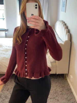 Vinröd kofta från Zara  - Vinröd kofta från Zara med volangkant nertill och längs knäppningen. Koftan är i storlek S, en perfekt kofta ny till våren med ett par svarta eller vita jeans💗 pris kan diskuteras!