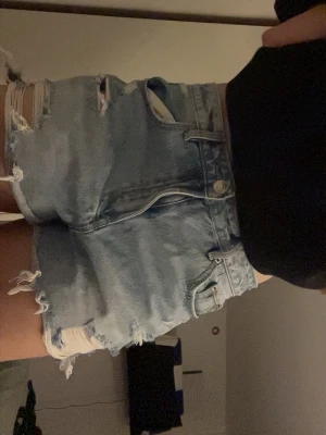 Ljusblåa jeansshorts - Säljer ett par ljusblåa högmidjade jeansshorts med slitna detaljer😽 Perfekta nu till våren. Använda men bra skick! 