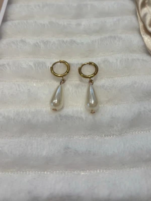 Guldörhängen med droppformade pärlor - Snygga örhängen med guldfärgade ringar och droppformade vita pärlor. Vi säljer även alla designerna på sista bilen och alla finns i både guld och silver💞