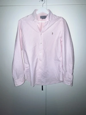 Rosa randig skjorta från Ralph Lauren - En riktigt go raffe skjorta. Rosa vit. Finns en liten fläck på höger arm men inte värsting. Hör av er via intresse sp kan pris diskuteras