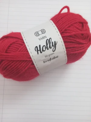 Rött garnnystan - Ett rött garnnystan från Holly, 50 gram, tillverkat av 100% akryl. Perfekt för stickning eller virkning av mjuka projekt. Garnet är lätt att tvätta i 40 grader. Har aldrig använts. Köptes på Rusta.