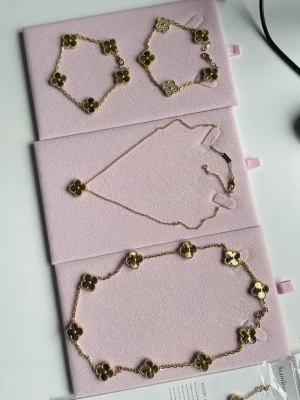 Guldfärgat halsband med blommor - Guldpläterade: hög kvalitet motståndskraftiga, halsbandet är 42cm, armband 18cm. Pris halsband med en klöver 499, armband 499, halsband med 10klövwr 799. Köper man två smycke den tredje billigaste är gratis.