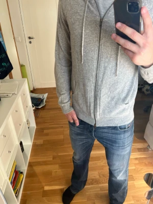 Grå hoodie med dragkedja och lappar - Snygg grå hoodie med dragkedja och huva. Hoodien har praktiska fickor framtill och coola förstärkta armbågslappar i mörkare grått tyg. Tillverkad i kashmir material som känns skönt mot huden. Perfekt för en avslappnad och stilren look. Skickas snabbt och gör av er vid minsta funderingar!!