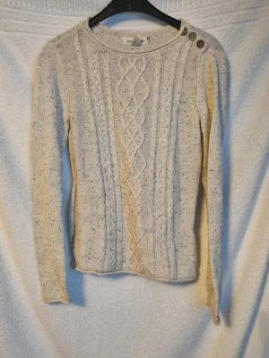 Stickad tröja - Krämvit stickad tröja med lite prickar i olika färger och har 3 knappar på ena axeln i storlek 158/164 från hm. Mycket fint skick.