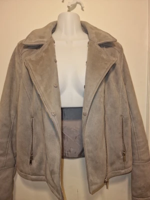 Grå teddyjacka från Isolde - Mjuk och fluffig yta med slätt innerfoder. Snygg till våren 🩶