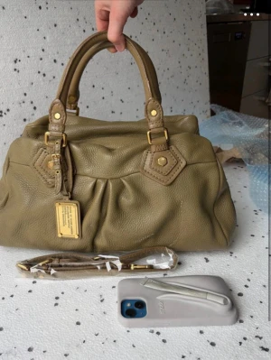 Khaki Vintage Marc Jacobs classic Q större modell - Saljer en vintage classic Q vintage Marc Jacobs väska i färgen khaki. Väskan har mindre slitage från normal användning (vänligen kolla bilderna) Observera att väskan är fylld på bilderna Oöppnad axelrem skickas med! Väskan är i en större modell, kontakta för mått vid intresse!