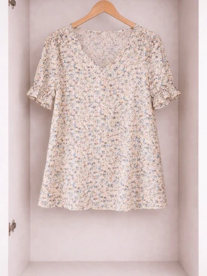 Blommig topp med volangärm - Söt topp med småblommigt mönster i ljusa pastellfärger. V-ringad hals och korta ärmar med volangkant ger en romantisk vibe. Tillverkad i ett lätt och luftigt tyg som passar perfekt till jeans eller kjol.