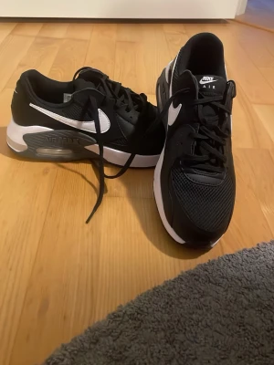 Nike Air Max svartvita sneakers - Snygga Nike Air Max sneakers i svart med vita detaljer och den klassiska swoosh-loggan på sidan. Ovandelen är i mesh och syntet för bra andningsförmåga och komfort. Sulan är vit med synlig Air-enhet för extra dämpning. Perfekta för en sportig och trendig look. Har inget paket kvar  