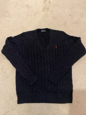Ralph Lauren cable knit sweater navy M dam - Säljer en äkta Ralph Lauren cable knit i mörkblå färg. Storlek M, passar true to size dam.  Väldigt snygg och klassisk modell som passar till allt. Bra skick utan större defekter.  Säljes då den inte används. Snabb affär prioriteras 💸 