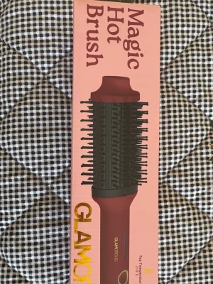 Stylingborste Magic Hot Brush  - Magic Hot Brush är en rund, elektrisk stylingborste i vinröd färg med svarta borst och detaljer. Perfekt för att skapa volym och lockar i håret. Borsten har en ergonomisk form och värmetåligt material för enkel styling.