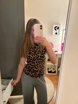 Leopardmönstrad topp med rund hals - Snygg topp med leopardmönster och rund halsringning. Modellen är ärmlös och har en normal passform. Aldrig använt. Priset kan diskuteras ❣️