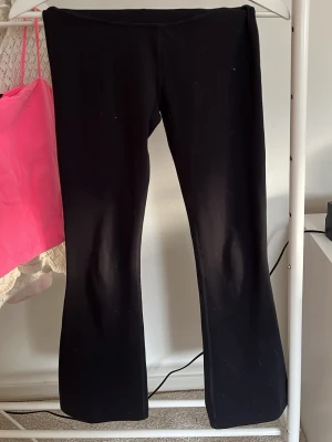 Svarta bootcut leggings från SOC - Säljer ett par svarta leggings från SOC med bootcut-modell. Tillverkade i stretchigt funktionsmaterial som andas och håller dig bekväm. Perfekta för träning eller chill dagar. Diskret logga i midjan och mjuk resår för skön passform.
