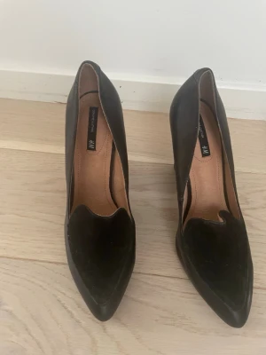 Svarta Klackskor från H&M - Säljer ett par svarta klackskor från H&M med chunky klack och spetsig tå. Riktigt fina i utmärkt skick, strl 37! Hör av er 💕