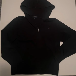 Svart hoodie från Polo Ralph Lauren - Svart hoodie från Polo Ralph Lauren med dragkedja framtill och klassisk huva. Priset kan diskuteras. Passar till allting. 