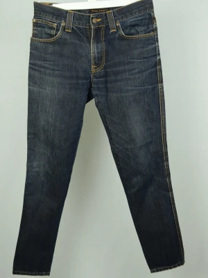 Nudie Slim Jim Jeans  - NUDIE JEANS Storlek : 31/32 - se mått Modell : Slim Jim Mått : A = 39CM - B = 97CM - C = 14,5CM Användning : Jeansen är i ett väldigt fint skick utan defekter Nypris : Cirka 1600SEK Modellen på bilden : 182CM och väger 73,5KG