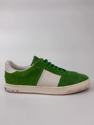 Valentino flycrew skor - Snygga sneakers i grönt mocka med vita läderdetaljer och vita sulor. Skorna har gröna skosnören och coola nitar på hälen. Perfekt för dig som vill sticka ut med färg och stil. Klassisk låg modell som passar till jeans eller shorts. Skorna har replacemnet soles.