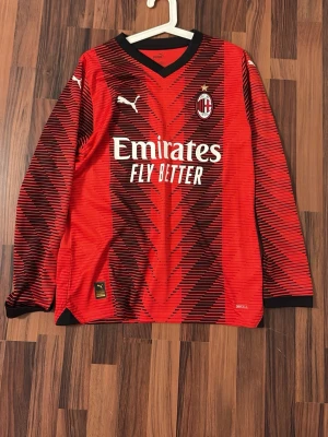 Långärmad AC Milan tröja maldini ( ÄKTA ) - Säljer en röd och svart långärmad AC Milan matchtröja från Puma med Maldini och nummer 3 på ryggen. Tröjan har ett grafiskt mönster, klubbmärke på bröstet och sponsortryck fram och bak. Perfekt för fotbollsfans som vill sticka ut på planen. Dock så är maldini tryckt ändå när han inte gick där då men tröjan är äkta.