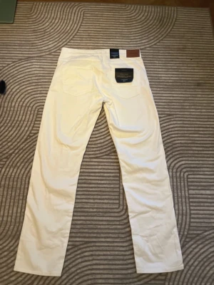 Vita jeans Lindbergh 1927, W33 L32 - Säljer ett par stilrena vita jeans från Lindbergh (1927 Premium). Modell med Superflex och “Cashmere Touch” för extra komfort och mjuk känsla.  Storlek W33 L32. Midjemått 41cm, innerbenslängd 81cm.  Postar mellan 1-3 dagar efter köp.  Hör gärna av dig om du har frågor eller vill ha fler bilder!