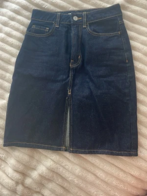 Mörkblå jeanskjol från Mango - Säljer snygg mörkblå jeanskjol från MANGO med slits fram! Älskar denna men tyvärr blivit för liten. Storlek 36. 
