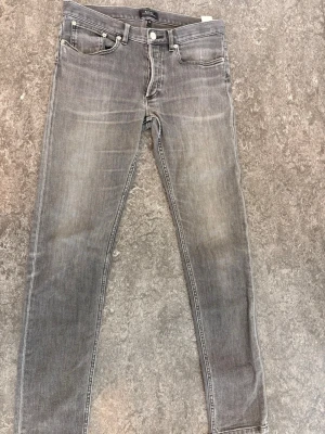 Gråa slim jeans från A.P.C. - Snygga gråa jeans från A.P.C. i modellen Petit New Standard. Jeansen har en slim passform, klassisk femficksdesign och är tillverkade i denim. Perfekta för dig som gillar stilrena och tidlösa plagg med en modern twist. 2500 nypris 