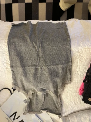 Grå ribbad body - En enkel och stilren grå body i ribbat material. Bodyn har breda axelband och rundad halsringning. Perfekt att matcha med jeans eller kjol för en avslappnad look. Materialet känns mjukt och stretchigt för extra komfort.