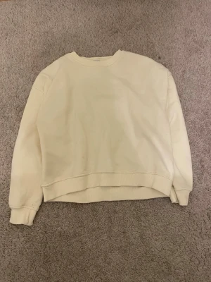 ljus gul oversized sweatshirt - En enkel och stilren ljus gul sweatshirt med rund hals och ribbade muddar vid ärmar och nederkant. Oversized passform som ger en avslappnad vibe. Perfekt att matcha med jeans eller mjukisbyxor.