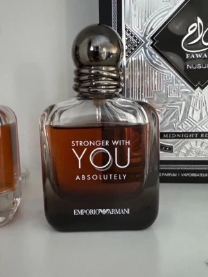 Emporio Armani Stronger With You - Emporio Armani Stronger With You Absolutely är en elegant parfym i en stilren glasflaska med mörkbrun toning och metallisk rund kork. Flaskan har en modern, maskulin design och text i vitt på framsidan. Perfekt för dig som gillar exklusiva dofter. 50ml