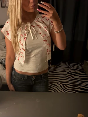 Vit bolerotopp med röda detaljer - Söt vit bolerotopp med röda mönster och knyt framtill. Kortärmad och croppad modell💗