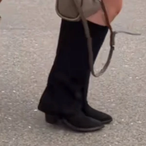 Svarta stövlar med klack - Snygga svarta stövlar i mocka med klack och spetsig tå. Perfekta för att ge en elegant touch till din outfit. De är knähöga och passar bra till både kjol och byxor.