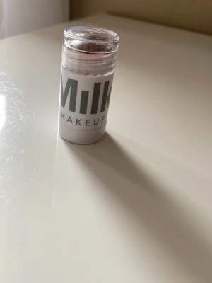 Milk Makeup blaze läpp, kind stick - Säljer ett bronze läpp och kind i stickformat från Milk Makeup. Färgen är en naturlig bronze nyans som ger kinderna ett fräscht glow.